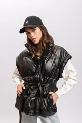 Chaleco puffer marrón de cuero sintético con cuello alto y cierre frontal con botones a presión.