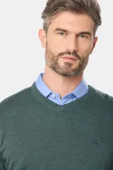 Suéter de tejido fino color azul marino, con cuello en V y manga larga. Presenta un pequeño logo bordado en el pecho.