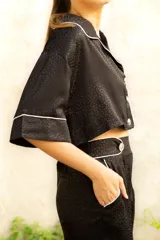 Pantalón de vestir negro con estampado animal print, corte palazzo y cintura alta.