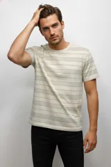 Remera de algodón de manga corta con cuello redondo, diseño de rayas horizontales finas en tonos neutros y corte holgado.