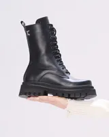 Borcego negro de cuero con cordones, caña media y suela track.