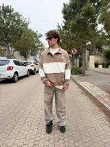 Buzo tipo polo de corte relajado y fit boxy, con diseño de bloques de color en bordó y blanco. Presenta cuello camisero con cierre frontal parcial y logo bordado en el pecho.