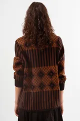 Sweater de cuello alto con diseño de tejido jacquard en tonos marrones y negros, con patrón geométrico y de rayas verticales, de manga larga con puños acanalados.