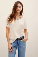 Remera de lino y viscosa color blanco, de corte holgado, manga corta y escote en V con detalle de aplicación brillante.