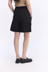 Bermuda de tiro alto color blanco, de calce amplio y diseño sastrero. Cuenta con pinzas delanteras y lazo ajustable en la cintura.