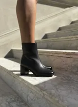 Botas de caña corta confeccionadas en cuero negro con textura granulada, diseño de punta cuadrada y taco bloque de altura media.