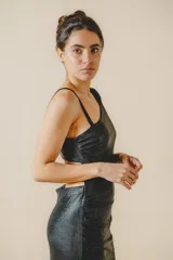 Vestido largo negro de fiesta, con un hombro descubierto, corte ajustado, drapeado lateral y tajo alto en la pierna.