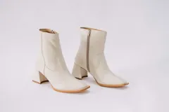 Botas cortas de cuero color crema, con cierre lateral y taco cuadrado. Forro, capellada y plantilla 100% cuero.