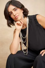Blusa negra sin mangas con escote redondo y detalle de fruncido en el cuello.