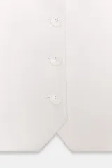 Chaleco blanco de corte entallado, con escote pico profundo y cierre frontal de botones.