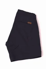 Bermuda azul con bolsillos laterales y traseros, con detalle de etiqueta de cuero en el bolsillo.