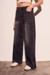 Pantalón de jean negro con efecto desgastado, corte wide leg y cierre con cremallera en los tobillos.