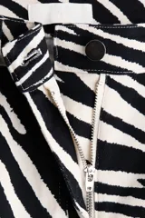 Pantalón de cinco bolsillos en sarga de algodón, de cintura estándar y diseño barrel con estampado de cebra en blanco y negro.