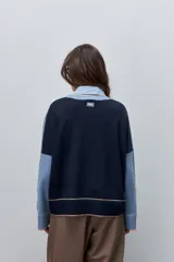 Sweater tejido celeste de calce relajado con cuello redondo, hombros caídos y puños y ruedo acanalados con detalles en tono tostado.