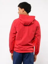 Campera deportiva Umbro del Club Nacional de Football, modelo Summit. Presenta un diseño con bloques de color en azul, rojo y blanco, con capucha, cierre frontal y bolsillos laterales con cierre. Incluye el logo de la marca y el escudo del club en el pecho.