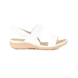 Sandalias bajas Korium Alaida de cuero sintético blanco, con dos tiras anchas sobre el empeine, ajuste con velcro en el tobillo y plantilla acolchada color beige.