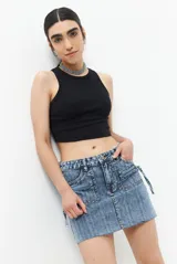 Minifalda de jean azul con lavado claro, cuatro bolsillos y dos bolsillos adicionales con cierre.