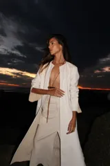 Tapado marrón de cuero con corte a la rodilla, mangas largas y aberturas laterales.