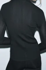 Jersey de punto con lana, de cuello subido y manga larga. Presenta un diseño ajustado con detalle de costuras verticales marcadas en el frente.