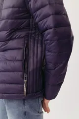 Campera puffer de diseño acolchado en color azul oscuro, con cuello elevado, cierre frontal completo y bolsillos laterales con cierre. Incluye un bolsillo adicional en el pecho y capucha oculta.