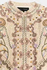 Chaqueta de hilatura de algodón en color beige, de cuello redondo y manga larga, con aplicaciones de bordados a contraste.