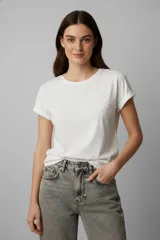 Remera de algodón blanca de manga corta con cuello redondo y detalle de bordado floral en la parte superior del pecho.