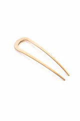 Horquilla para el pelo en forma de U, de diseño minimalista y acabado metálico en tono dorado.
