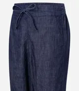 Pantalón de jeans de color azul oscuro, corte carrot (holgado en cadera y afunilado en pierna), con cintura alta ajustable mediante cordón.