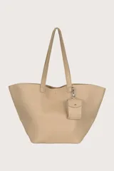 Bolso tipo shopper color beige con textura granulada y llavero colgante.