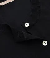 Cardigan de punto color beige, con cuello redondo, cierre frontal abotonado y puños y ruedo acanalados.