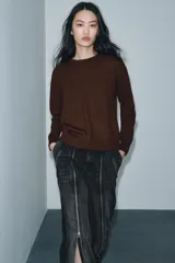 Jersey de punto liso color verde, con cuello redondo y manga larga. Confeccionado en hilatura de lana 100% con tacto suave.