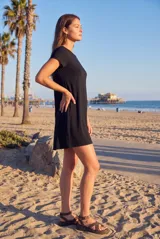 Vestido mini negro de manga corta y cuello redondo, confeccionado en mezcla de viscosa y elastano con diseño fluido y versátil.