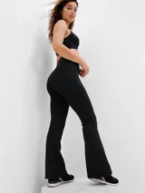 Calza de tiro alto con corte flare, confeccionada en tejido elástico de color negro.