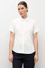 Camisa clásica blanca de manga corta, con cuello camisero y cierre frontal oculto con botones.