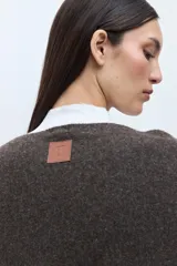 Capa color chocolate con cuello alto, botones decorativos en el hombro y ribete beige en los bordes.