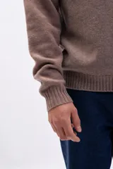 Buzo de tejido de punto con cuello redondo, mangas largas y puños acanalados, en color taupe.