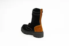Bota tipo borcego de caña media, confeccionada en una combinación de cuero gamuzado negro y detalles en cuero color suela en la parte trasera y lengüeta. Presenta suela track de goma negra y costuras a la vista.