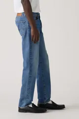 Jeans de corte recto y tiro mid-rise, color azul con lavado medio y efecto ligeramente desgastado, con cierre de botones.