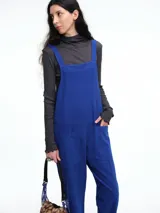 Mono largo de pana color verde oscuro, con breteles finos y silueta relajada de pierna amplia.