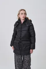 Campera puffer negra de corte largo y holgado, con capucha, cierre frontal y bolsillos delanteros con solapa.