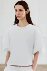 Camiseta blanca de algodón con cuello redondo y mangas cortas abullonadas.