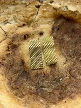 Par de aros colgantes rectangulares color dorado, con diseño tejido tipo rejilla.