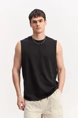 Musculosa oversize negra de algodón con efecto acid wash y diseño de líneas simples.