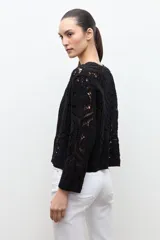 Chaqueta tejida a crochet en color beige claro, de diseño abierto y manga larga con patrones geométricos calados.