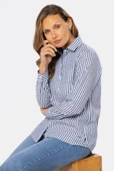 Camisa de manga larga con rayas verticales grises y blancas, corte holgado y bolsillo en el pecho.