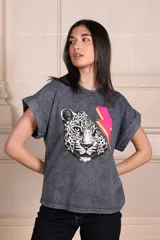 Remera gris con efecto gastado, cuello redondo y mangas cortas con dobladillo. Estampado frontal de un rostro de leopardo en blanco y negro con un rayo rosa y amarillo.
