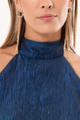 Vestido largo azul de tafeta con textura corrugada, cuello halter, espalda descubierta y falda amplia con tajo lateral y volados.