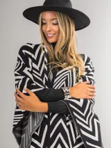 Ruana italiana con diseño zig zag en tonos negro y beige. Tejido suave y cálido.