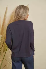 Buzo tejido color azul marino, de manga larga, escote en V y tajitos en los costados. Presenta botones dorados decorativos en los puños.