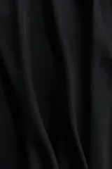 Pollera midi negra de tiro alto, confeccionada en tejido satinado con caída suave y vuelo sutil en el bajo.